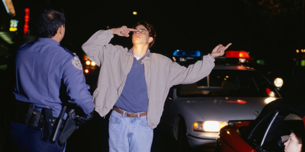 Cop conducting a field sobriety test on a male driver